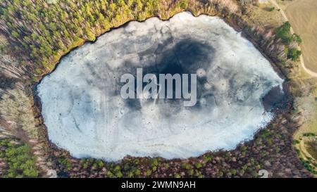 Vista aerea del lago nelle foreste lituane, inverno, natura selvaggia. Nome del lago "Kaniuku", distretto di Varena, Europa. Foto Stock