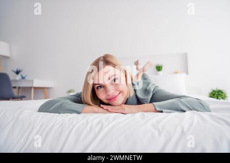 Ritratto ravvicinato di allegri capelli biondi indosso pigiama letto sdraiato goditi il tempo libero riposati a casa in casa senza trucco Foto Stock