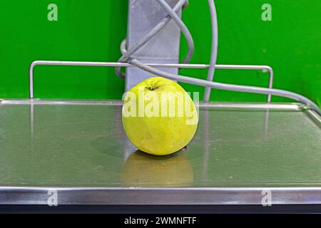 una mela verde giace sulla bilancia nel supermercato Foto Stock