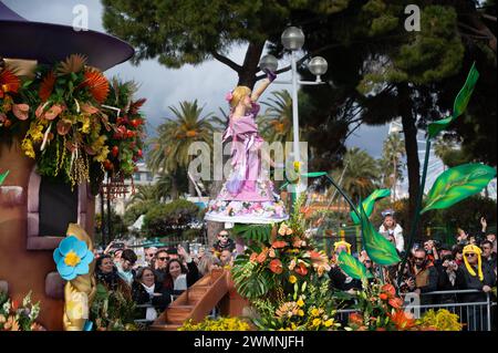 Le donne sui carri allegorici del Carnevale lanciano fiori alla folla nella battaglia dei fiori del carnevale di Nizza - 24 febbraio 2024 Foto Stock