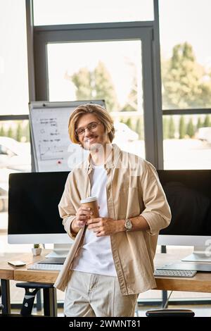 Professionale sorridente con bicchieri che tengono il caffè in un moderno ufficio, team di post-produzione Foto Stock