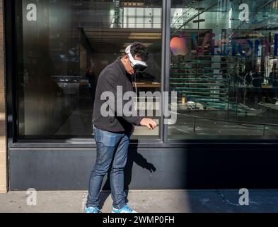 All'esterno dell'Apple store nel Meatpacking District di New York, un uomo prova la nuova cuffia Apple Vision Pro martedì 20 febbraio 2024. (© Richard B. Levine) Foto Stock