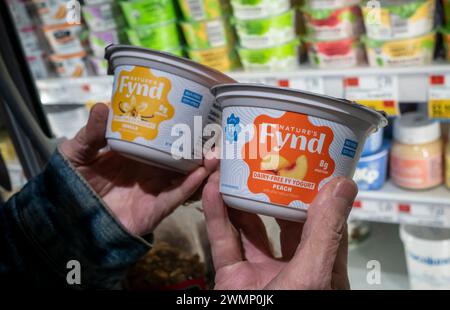 Mercoledì 21 febbraio 2024, un acquirente sceglie i contenitori di yogurt non latticini a base vegetale Nature’s Fynd in un supermercato a New York. Il prodotto è ottenuto da Fy Protein, un microrganismo fungino del Parco Nazionale di Yellowstone e quindi fermentato. (© Richard B. Levine) Foto Stock