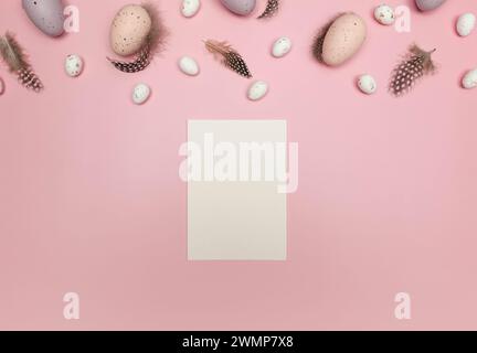 Vista dall'alto delle uova di pasqua, delle piume e del cartellino bianco su sfondo rosa. Composizione creativa pasquale, primavera, piatto, spazio copia. Foto Stock
