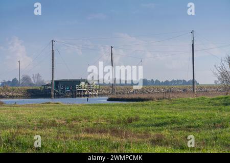 Comacchio, Italia. 25 febbraio 2024. Le baracche di legno dei pescatori nella laguna di Comacchio Foto Stock