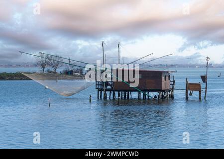 Comacchio, Italia. 25 gennaio 2024. Vista panoramica delle baracche di pescatori in legno nella valle di Comacchio Foto Stock