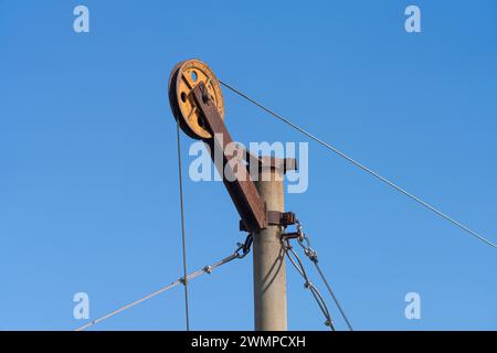 le pulegge su un pilone per sollevare le reti da pesca Foto Stock