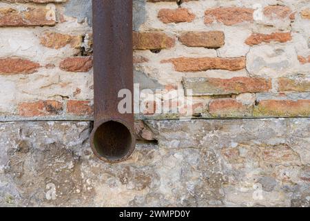 il vecchio tubo di una grondaia su un muro di mattoni Foto Stock