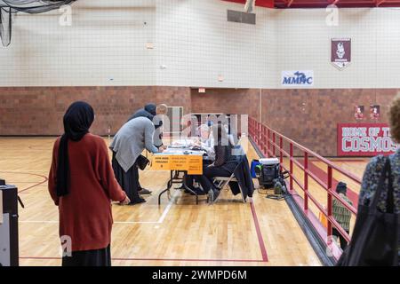 Hamtramck, Michigan, Stati Uniti. 27 febbraio 2024. Le persone si registrano per votare alla Hamtramck High School alle elezioni presidenziali primarie del Michigan. Specialmente ad Hamtramck e Dearborn, dove ci sono un gran numero di arabi-americani, molti elettori hanno pianificato di votare 'senza impegno nelle primarie democratiche. Molti arabi-americani sono furiosi per il sostegno di Joe Biden a Israele nella guerra di Gaza. I bombardamenti israeliani sono costati decine di migliaia di vite palestinesi. Crediti: Jim West/Alamy Live News Foto Stock