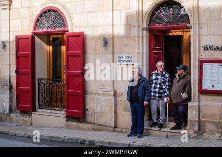 Uomini che chiacchierano in una porta, Mellieha, Malta Foto Stock