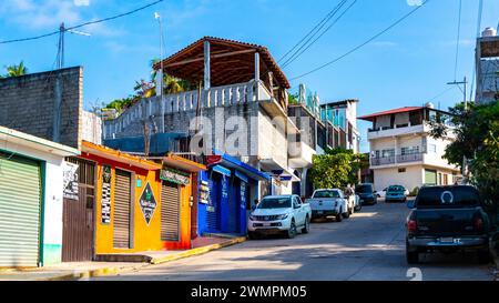 Strade colorate Cars High Traffic Stores People Buildings and Trade a Zicatela Puerto Escondido Oaxaca, Messico. Foto Stock
