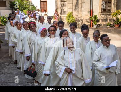 Vestito di bianco, il coro canta mentre entra nella Cattedrale di San Giuseppe per la messa domenicale cattolica a Stone Town, Zanzibar, Tanzania. Foto Stock