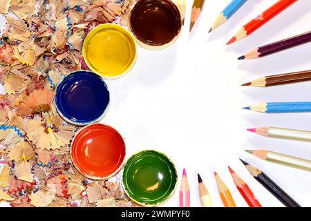 Sul tavolo si trovano matite colorate affilate, trucioli di legno e vasi di vernice ad acquerello. Foto di alta qualità Foto Stock