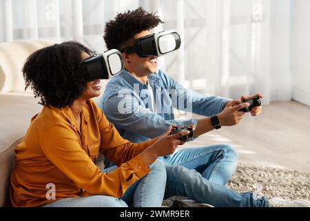 Esilarante coppia afroamericana immersa in un gioco di realtà virtuale Foto Stock