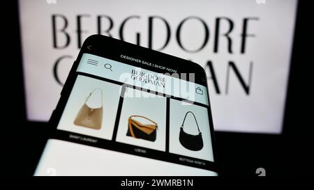 Smartphone con sito Web dell'azienda statunitense di grandi magazzini di lusso Bergdorf Goodman Inc. Davanti al logo aziendale. Mettere a fuoco in alto a sinistra sul display del telefono. Foto Stock