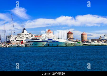 Grecia viaggiare, Dodecaneso. Isola di Rodi. Porto di Mandraki con navi da crociera e vecchi windmils Foto Stock