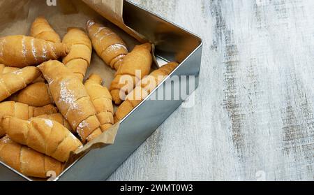 Una tazza di tè, un croissant su un vassoio Croissant. Spazio libero per il testo. appena sfornato. croissant in un cestino sul tavolo del buffet. Colazioni, business mee Foto Stock