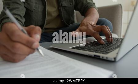 Vista ravvicinata uomo irriconoscibile ragazzo maschio che lavora laptop da casa navigare su Internet colpo ritagliato uomo d'affari che scrive al computer scrivere appunti scrivere Foto Stock