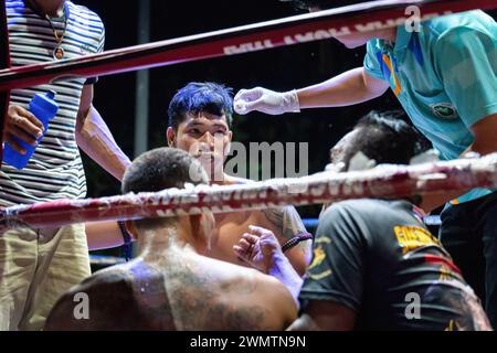 Koh Chang, Thailandia. 24 febbraio 2024. Il pugile vincitore Frame Payak, al centro, viene visto parlare con l'organizzatore mentre riceve un trattamento, alla fine della lotta, durante lo spettacolo settimanale Muay Thai Fights, organizzato dalla Koh Chang Fight School, sull'isola di Koh Chang. Il match di pugilato thailandese tra Frame Payak e Petch si nel è stato vinto da Frame Payak per KO. Credito: SOPA Images Limited/Alamy Live News Foto Stock