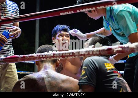 Koh Chang, Thailandia. 24 febbraio 2024. Il pugile vincitore Frame Payak, al centro, viene visto parlare con l'organizzatore mentre riceve un trattamento, alla fine della lotta, durante lo spettacolo settimanale Muay Thai Fights, organizzato dalla Koh Chang Fight School, sull'isola di Koh Chang. Il match di pugilato thailandese tra Frame Payak e Petch si nel è stato vinto da Frame Payak per KO. Credito: SOPA Images Limited/Alamy Live News Foto Stock