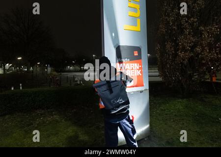 Amburgo, Germania. 28 febbraio 2024. Un attaccante appende i poster che leggono "avvertimento sciopero oggi" alla Lufthansa Technik. Il personale di terra della Lufthansa fa un attacco di tre giorni. Credito: Bodo Marks/dpa/Alamy Live News Foto Stock