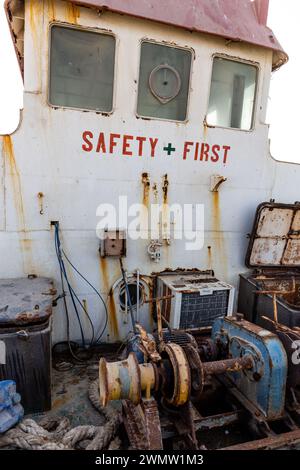 Ponte demolito e arrugginito di una nave da carico con vecchio ponte (passaruota), dipinto "Safety First", macchinari, vecchio verricello, lavato a terra negli Emirati Arabi Uniti. Foto Stock