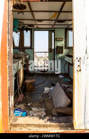 Umm al Quwain, Emirati Arabi Uniti, 11.11.20. Ammira attraverso una timoneria demolita un relitto di una nave da carico dopo un disastro marino, dall'interno del ponte con il comune Foto Stock