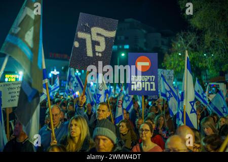 Haifa, Israele - 24 febbraio 2024: La folla di persone con vari segni e bandiere protesta contro il governo, chiedendo di assumersi la responsabilità di t Foto Stock