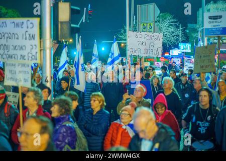 Haifa, Israele - 24 febbraio 2024: La folla di persone con vari segni e bandiere protesta contro il governo, chiedendo di assumersi la responsabilità di t Foto Stock