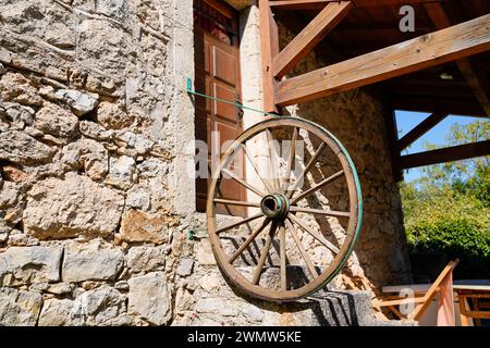 fattoria tipica edificio antico con una vecchia ruota del carro dei cavalli in facciata nella lozere aveyron Foto Stock