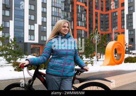 Una donna atletica ama viaggiare in città in bicicletta Foto Stock