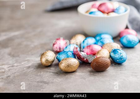 Uova di cioccolato pasquale avvolte in un foglio di alluminio sul tavolo della cucina. Foto Stock