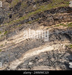 Superficie di roccia marina resistente agli agenti atmosferici. Sfondo della superficie delle pareti in pietra vulcanica invecchiata con crepe e graffi. Isola di Ischia, Italia. Foto Stock