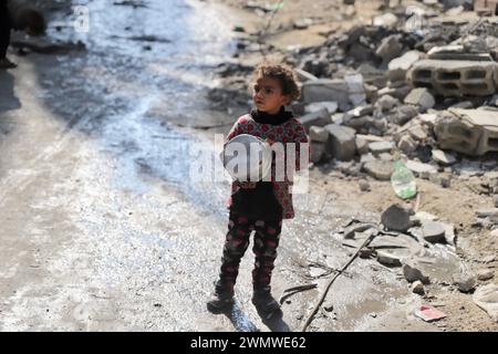 Gaza. 27 febbraio 2024. Un bambino aspetta di ricevere cibo cucinato in un campo profughi nel nord della Striscia di Gaza, 27 febbraio 2024. L'osservatore permanente dello Stato palestinese presso le Nazioni Unite, Riyad Mansour, martedì ha detto al Consiglio di sicurezza che Gaza sta attualmente vivendo una carestia, che peggiora ogni giorno a causa della continua "aggressione criminale” da parte di Israele. "Dobbiamo fermarci un momento e riflettere su cosa significhi veramente", Mansour si è rivolto alla riunione del Consiglio di sicurezza sulla protezione dei civili nei conflitti armati. Crediti: Mohammed Ali/Xinhua/Alamy Live News Foto Stock