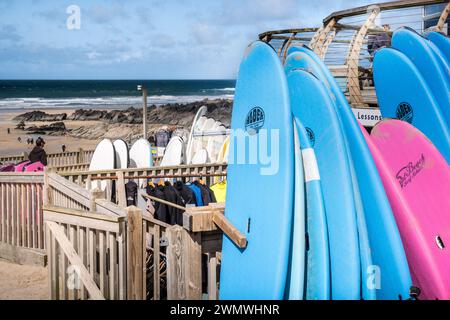 Tavole da surf colorate impilate e disponibili per il noleggio presso il negozio di surf a Fistral Beach a Newquay in Cornovaglia in Inghilterra nel Regno Unito. Foto Stock