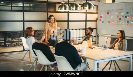 Gli uomini d'affari in una sala riunioni sono impegnati in una discussione vivace. Lavorano insieme come un team, creando idee creative per un co-tech di successo Foto Stock