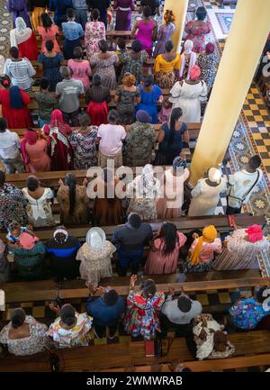 Guardando in basso la colorata congregazione della messa domenicale cattolica nella Cattedrale di San Giuseppe, Stone Town, Zanzibar, Tanzania Foto Stock