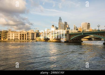 Un incrociatore della polizia che passa sotto il Southwark Bridge sul Tamigi con il grattacielo pieno di skyline della City of London, Londra, Inghilterra, Regno Unito Foto Stock