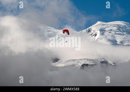 Parapendio tandem con il Monte bianco (4807 metri) avvolto dalla nebbia sullo sfondo in estate, Chamonix, alta Savoia, Francia Foto Stock