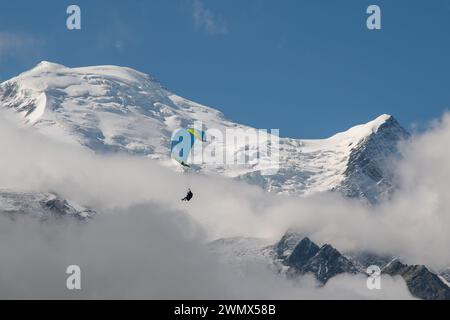 Parapendio tandem con il Monte bianco (4807 metri) avvolto dalla nebbia sullo sfondo in estate, Chamonix, alta Savoia, Francia Foto Stock