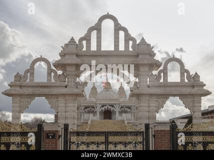 Londra, Regno Unito - 23 febbraio 2024 - arcata d'ingresso del tempio Neasden (BAPS Shri Swaminarayan Mandir) su un bel cielo nuvoloso. Cancelli di Neasd Foto Stock