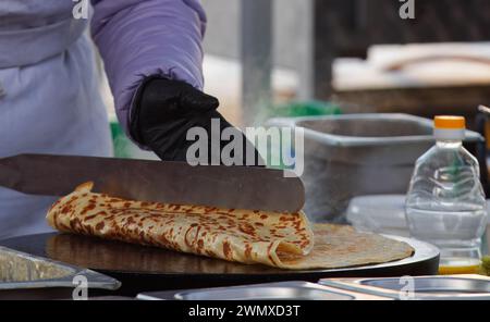 Il corpo centrale di uno chef che prepara crepes e pancake francesi al mercato agricolo di Praga, Naplavka, Repubblica Ceca Foto Stock