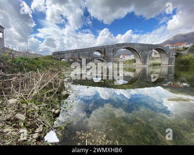 Passaggio storico: Suggestiva scena fluviale con ponte in pietra d'epoca Foto Stock