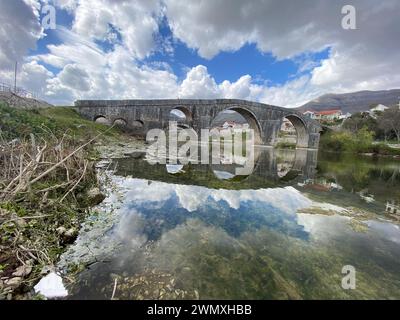 Passaggio storico: Suggestiva scena fluviale con ponte in pietra d'epoca Foto Stock