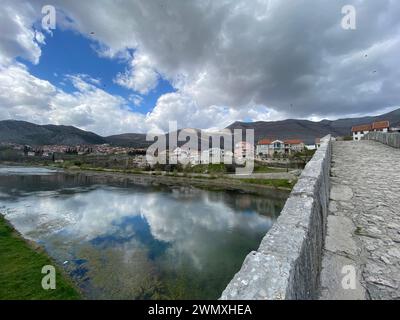 Passaggio storico: Suggestiva scena fluviale con ponte in pietra d'epoca Foto Stock