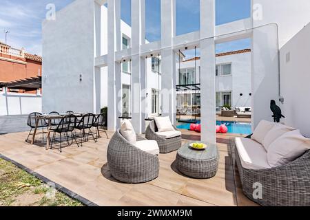 comodi mobili da giardino e tavoli da pranzo accanto a una piscina in una lussuosa residenza mediterranea Foto Stock