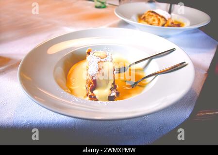 Un tradizionale Apfelstrudel bavarese servito con salsa alla vaniglia in Germania Foto Stock