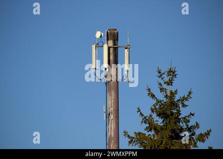 Torre di telecomunicazione con trasmettitori 4G e 5G. Stazione base cellulare con antenne di trasmissione su una torre di telecomunicazione su un cielo blu W. Foto Stock