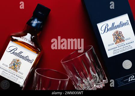 Whisky scotch miscelato da Ballantine con due bicchieri di whisky su fondo rosso. Editoriale illustrativo Foto Stock