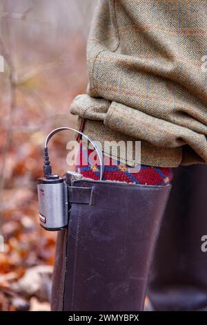 France Alsazia Rhine Forest, caccia alla selvaggina, Hunter che installa la batteria per i suoi calzini riscaldati Foto Stock